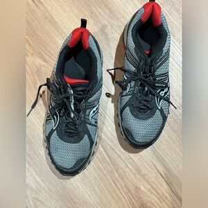 Saucony  gray and black tennis shoes with red accents in sole and back of heel.